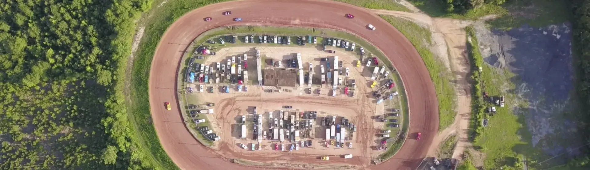 Cars racing around the dirt track at the Sumter Speedway